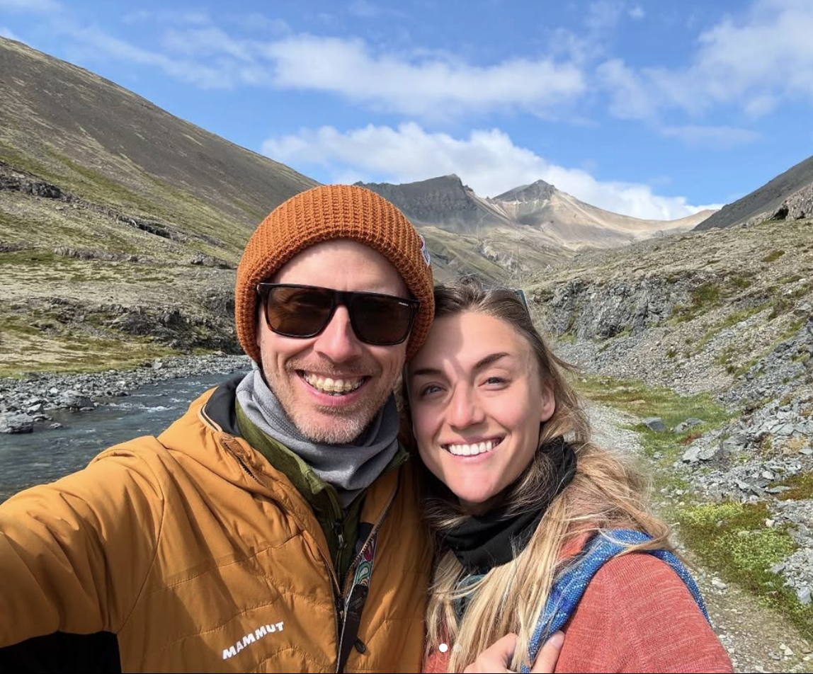 Adam and Kelsey smiling together in a rocky mountain valley in Iceland